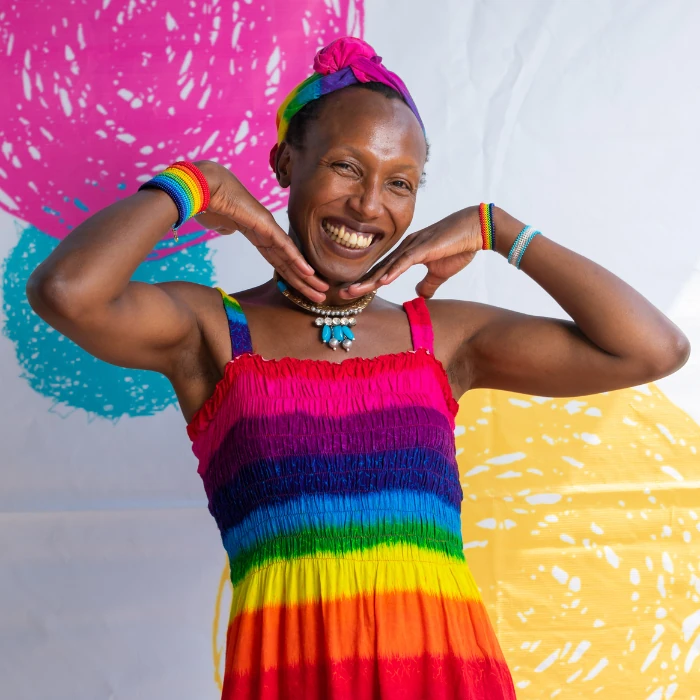 Arya Jeipea Karijo smiling widely and wearing a rainbow coloured dress.
